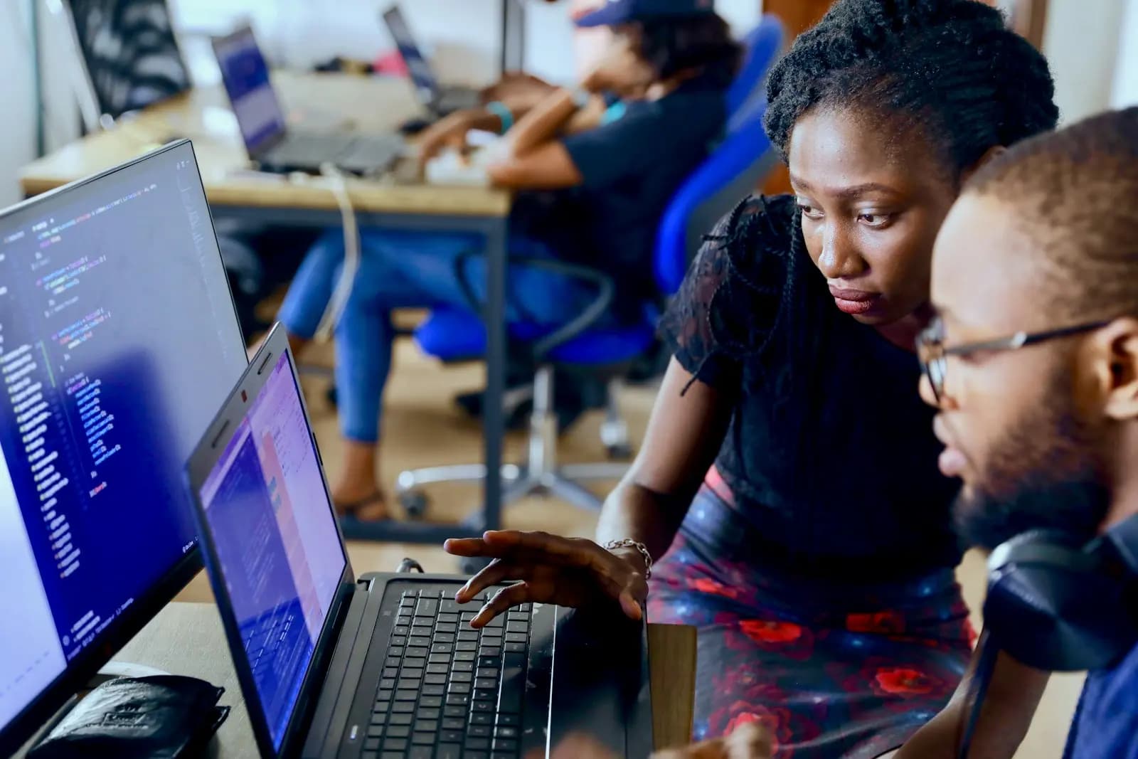 Colleagues reviewing work on a laptop